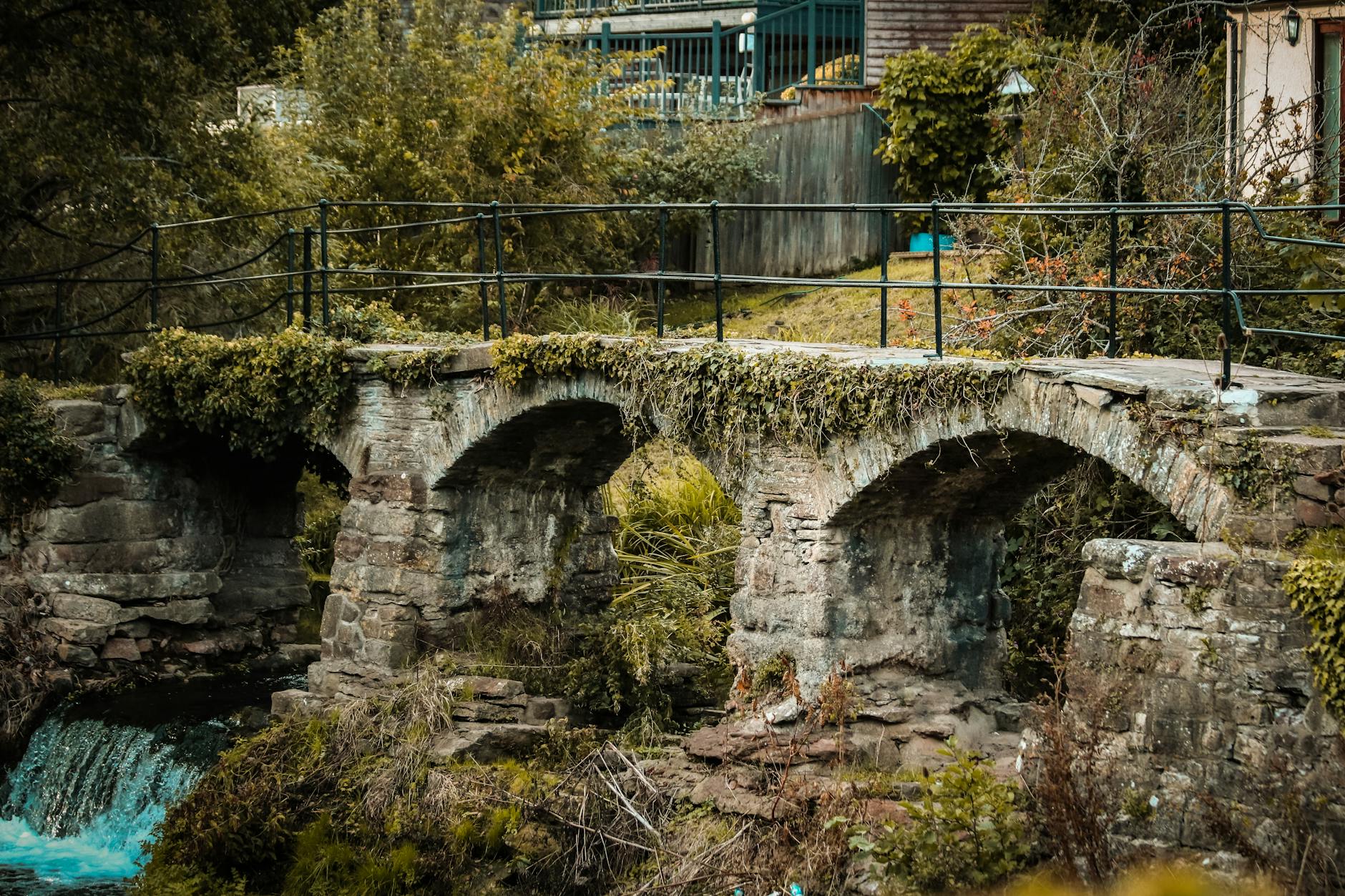 An old stone bridge crossing a gentle stream in a picturesque English village