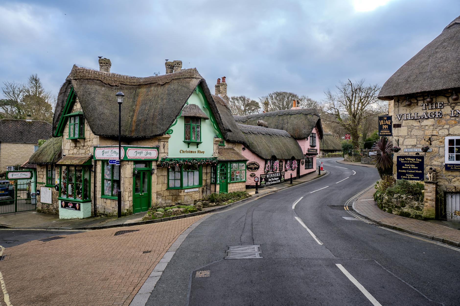 A peaceful Cotswolds village street lined with honey-stone cottages in morning light