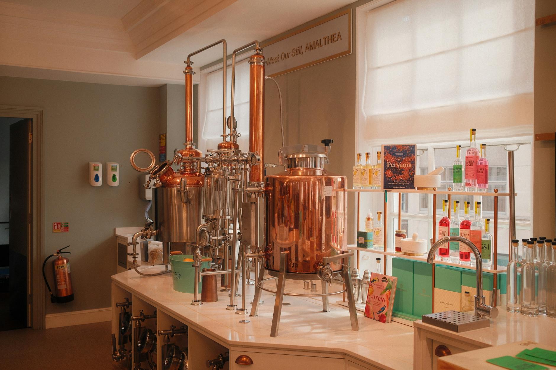Copper stills and craft gin bottles at a Cotswolds distillery