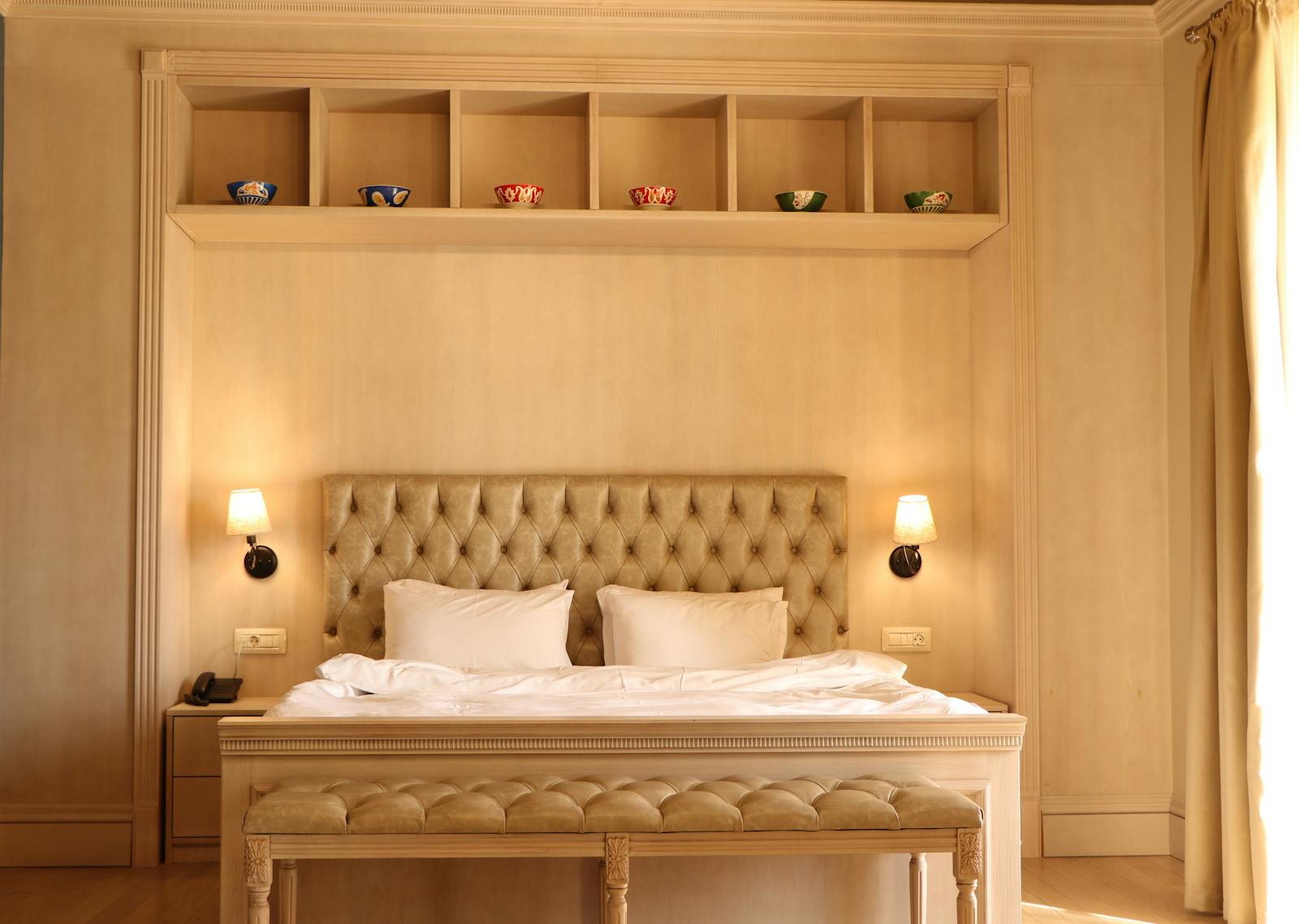 A chic hotel room with a plush tufted headboard and elegant interior design