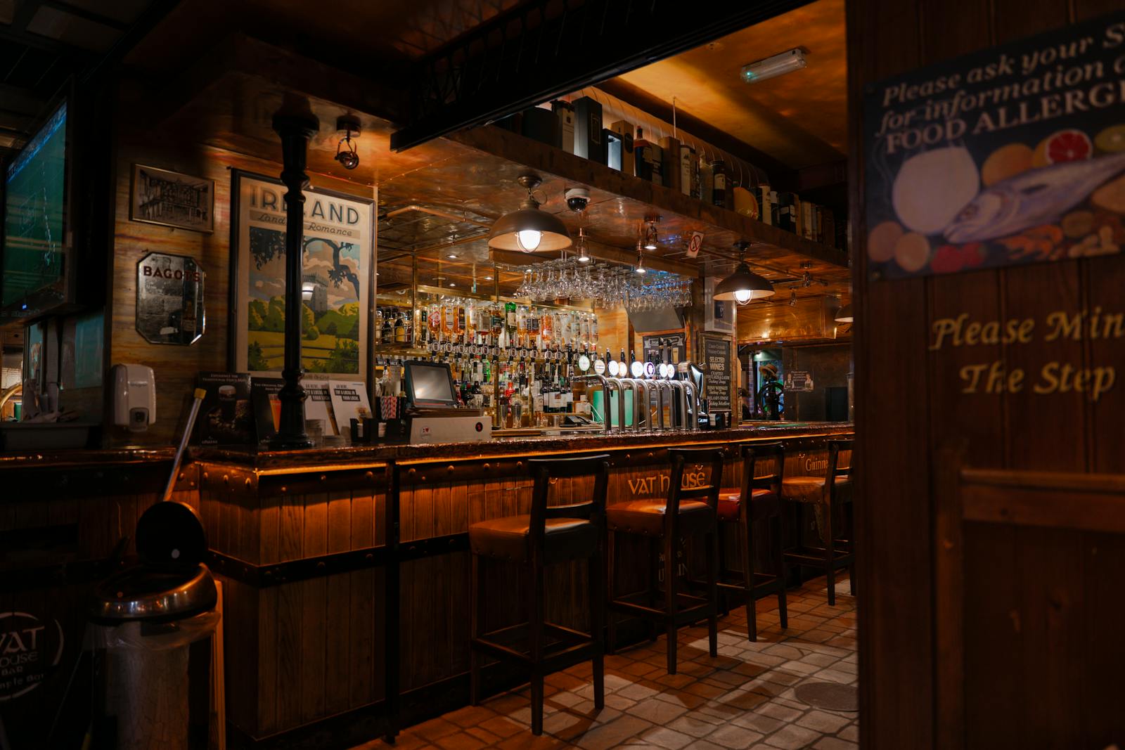 The warm, inviting interior of a traditional pub with a wooden bar