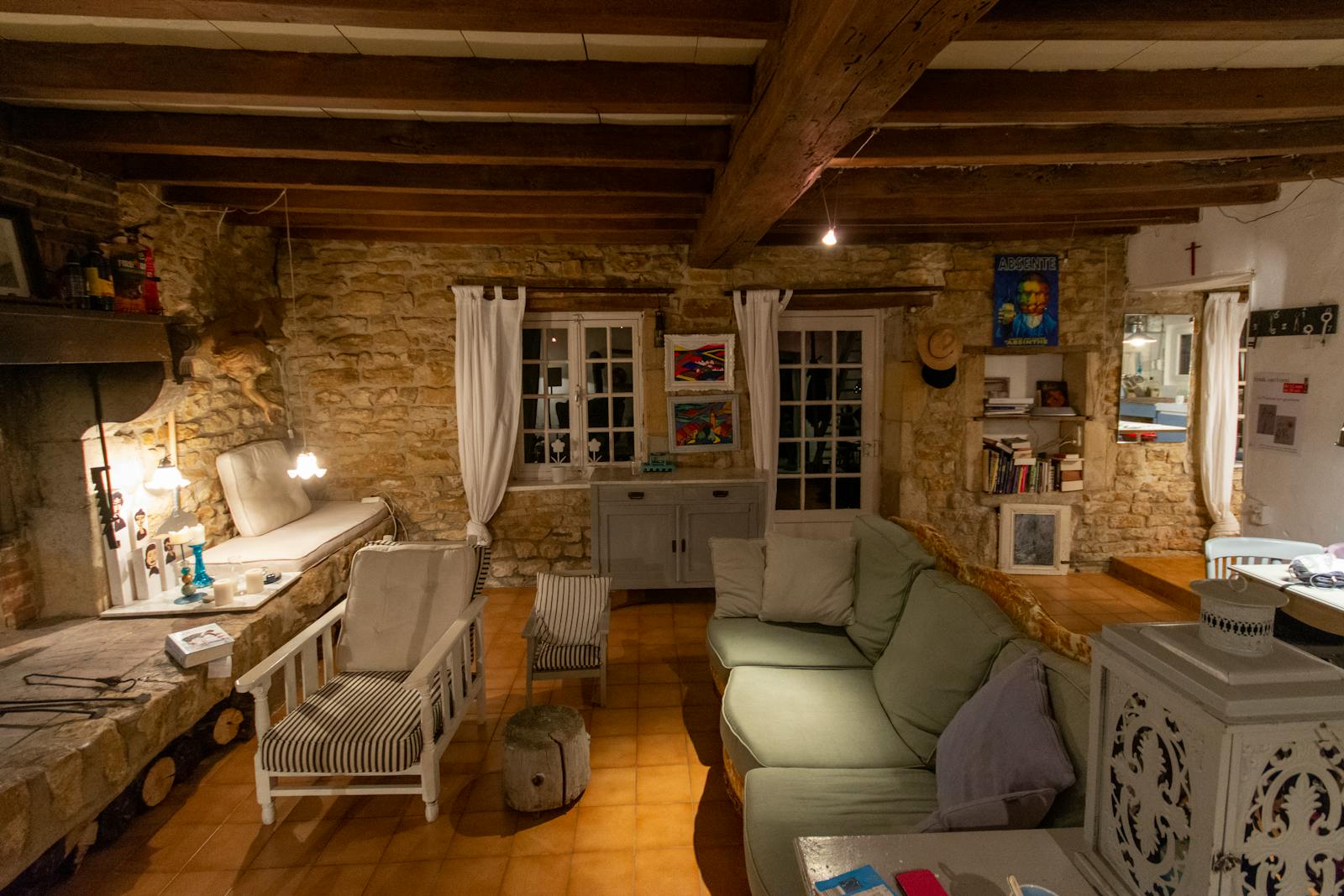 A cosy cottage living room with stone walls, wooden beams and comfortable seating