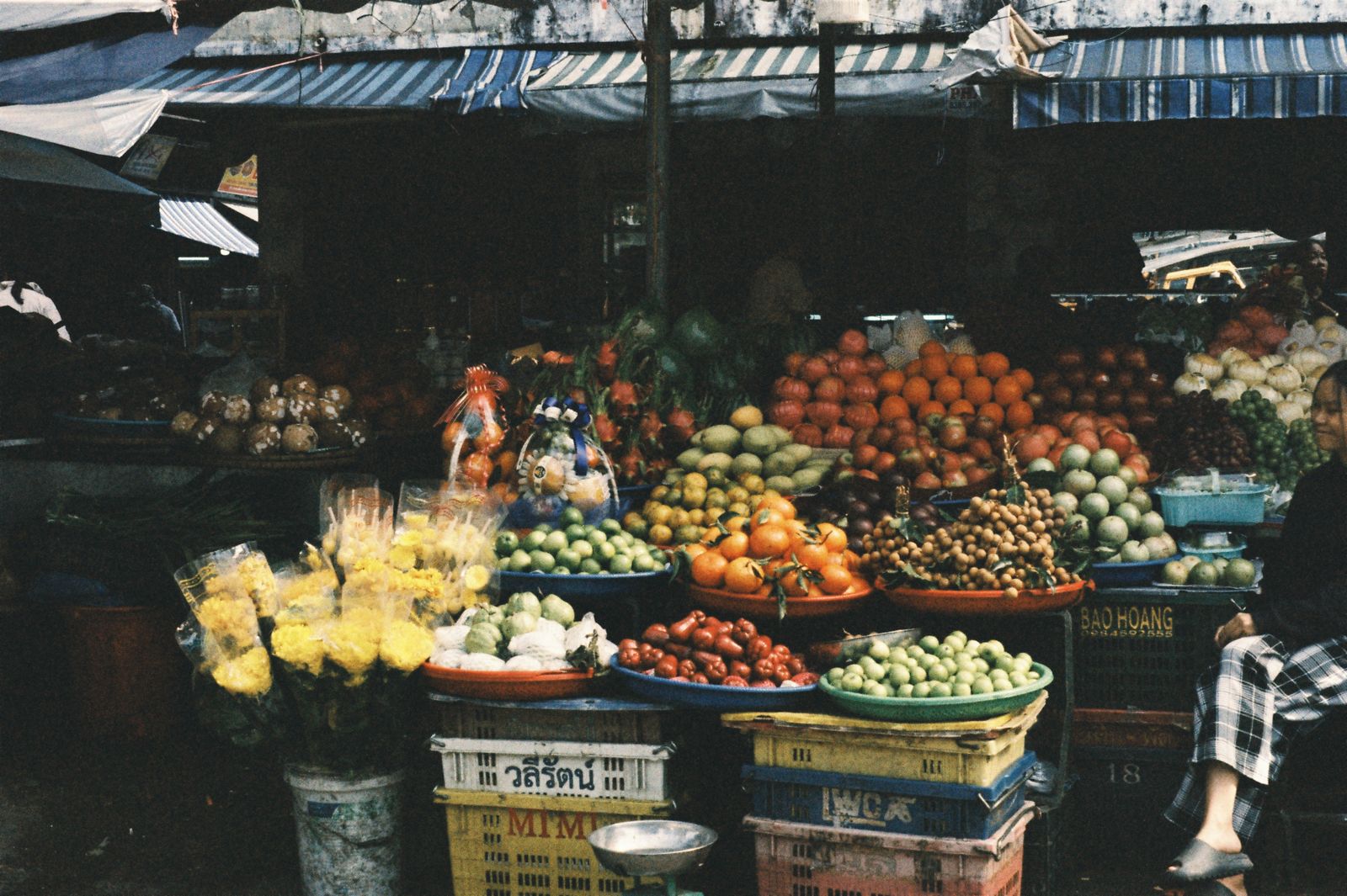 A bustling outdoor market stall displaying colourful fruit and vegetables