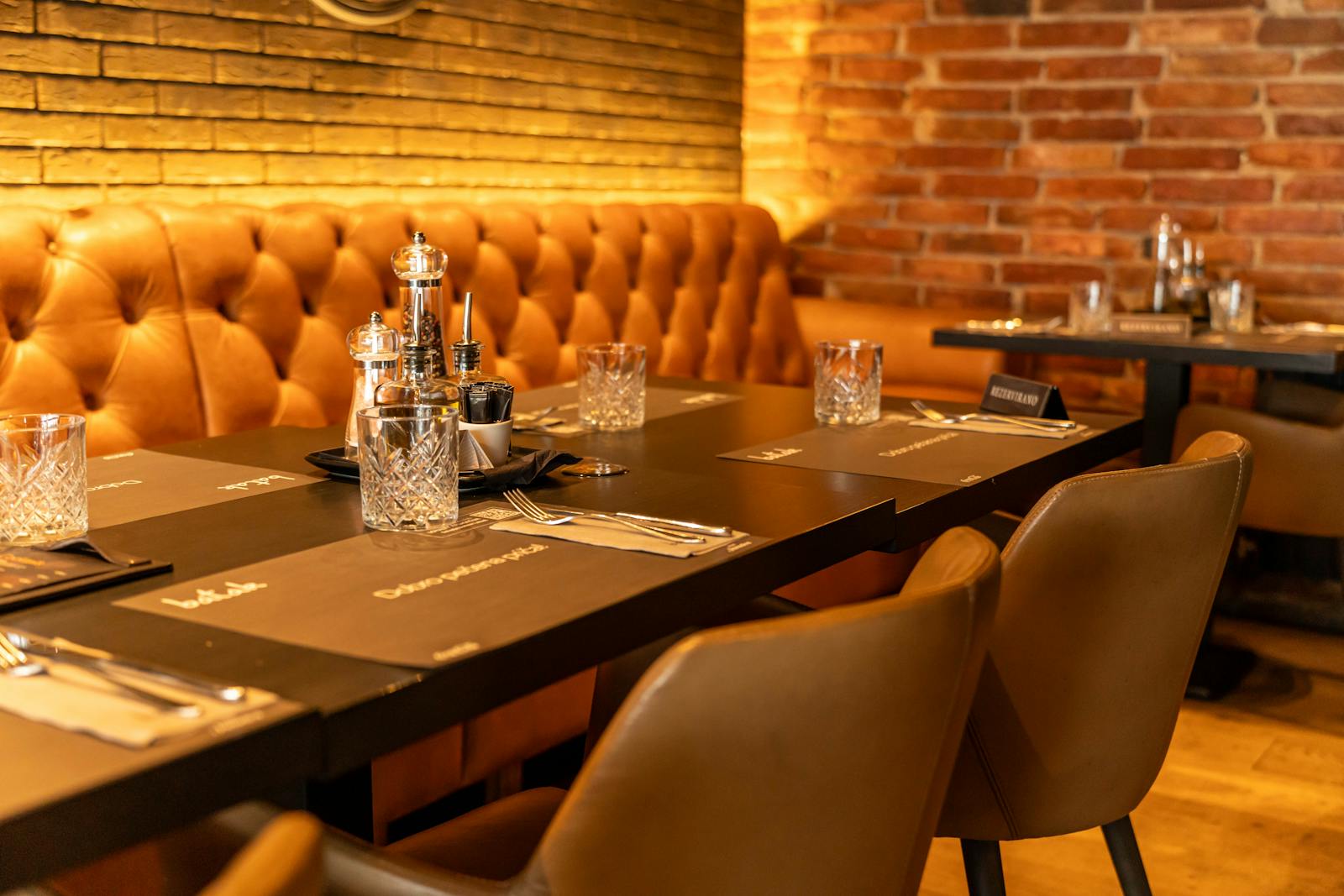 A warm and inviting restaurant interior with elegant leather seating and table settings