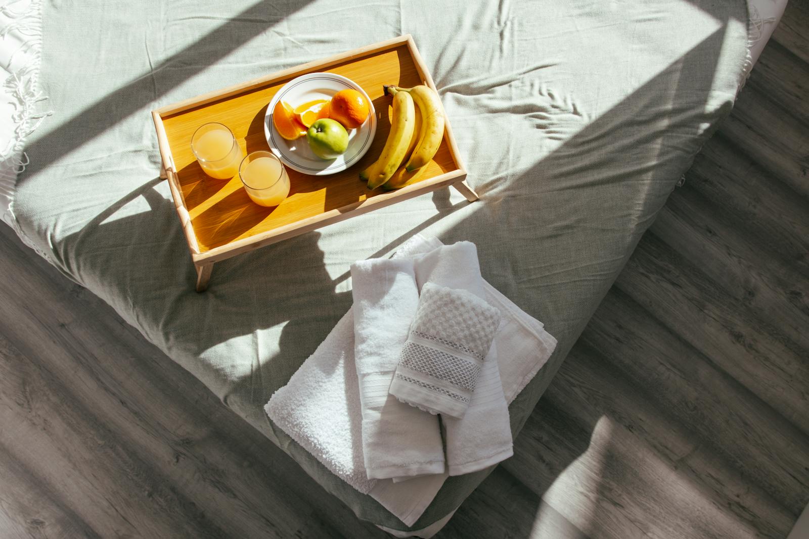A sunlit B&B bedroom with a breakfast tray on a neatly made bed