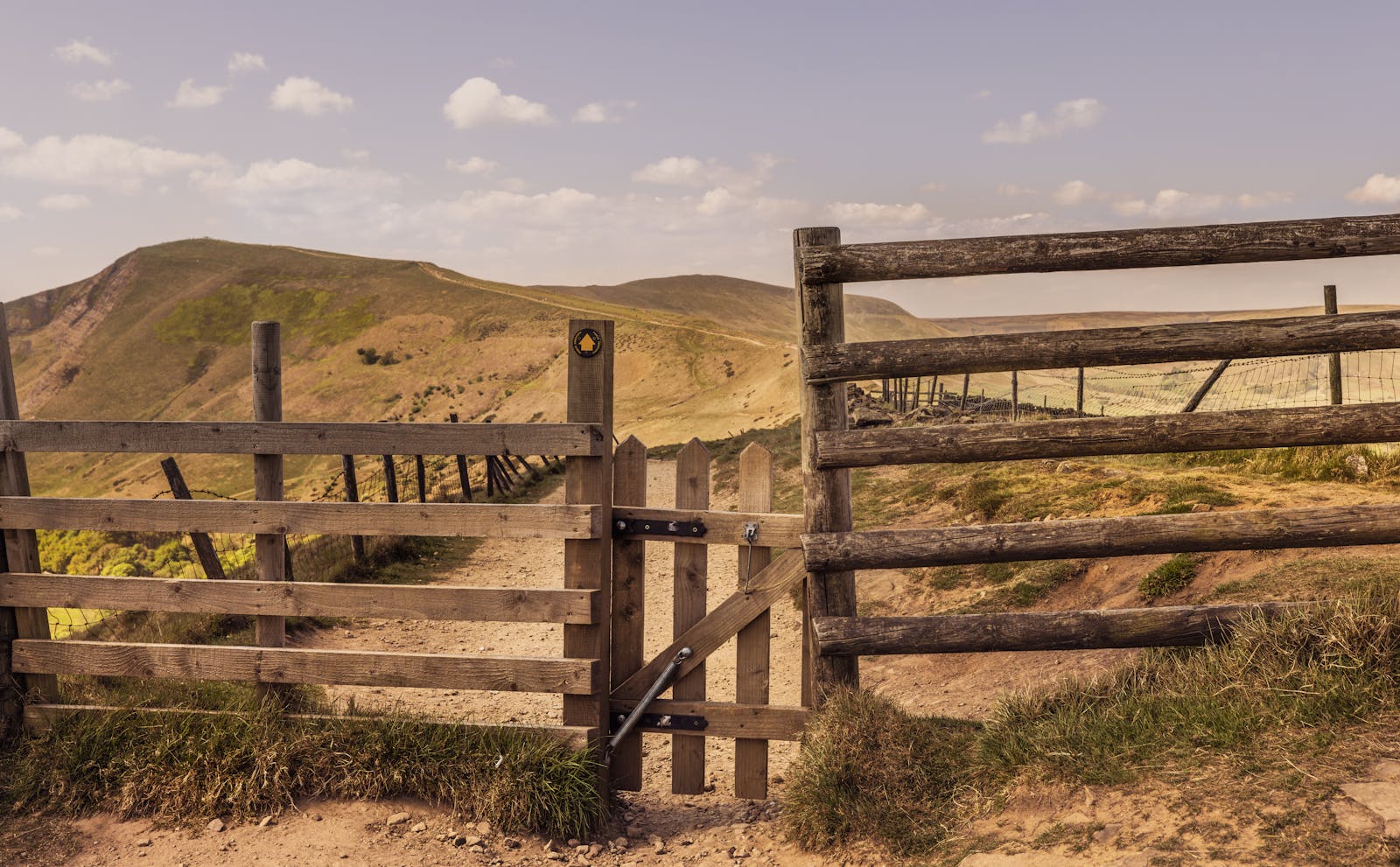 A rustic wooden gate along a hiking trail in the green English countryside