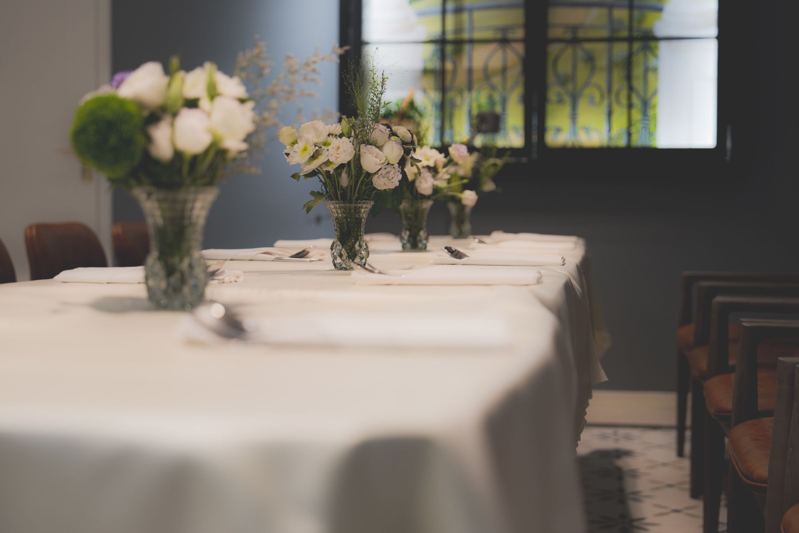 A luxurious dining table set with white linen and floral arrangements in an elegant hotel restaurant