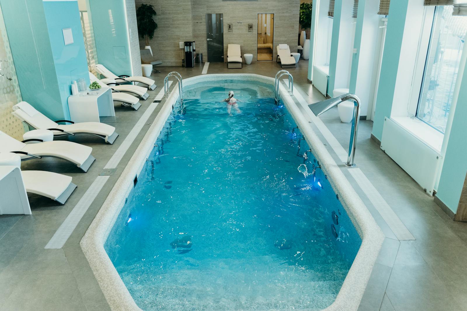 A bright indoor spa pool with loungers and a calm, relaxing atmosphere