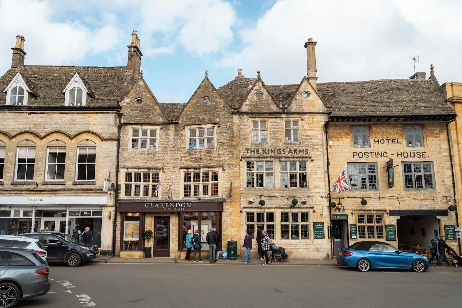 A quiet Cotswold street of traditional honey-coloured stone buildings