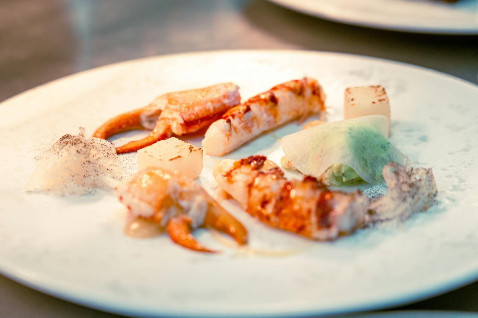 An elegant seafood dish with crab and lobster, creatively plated for fine dining