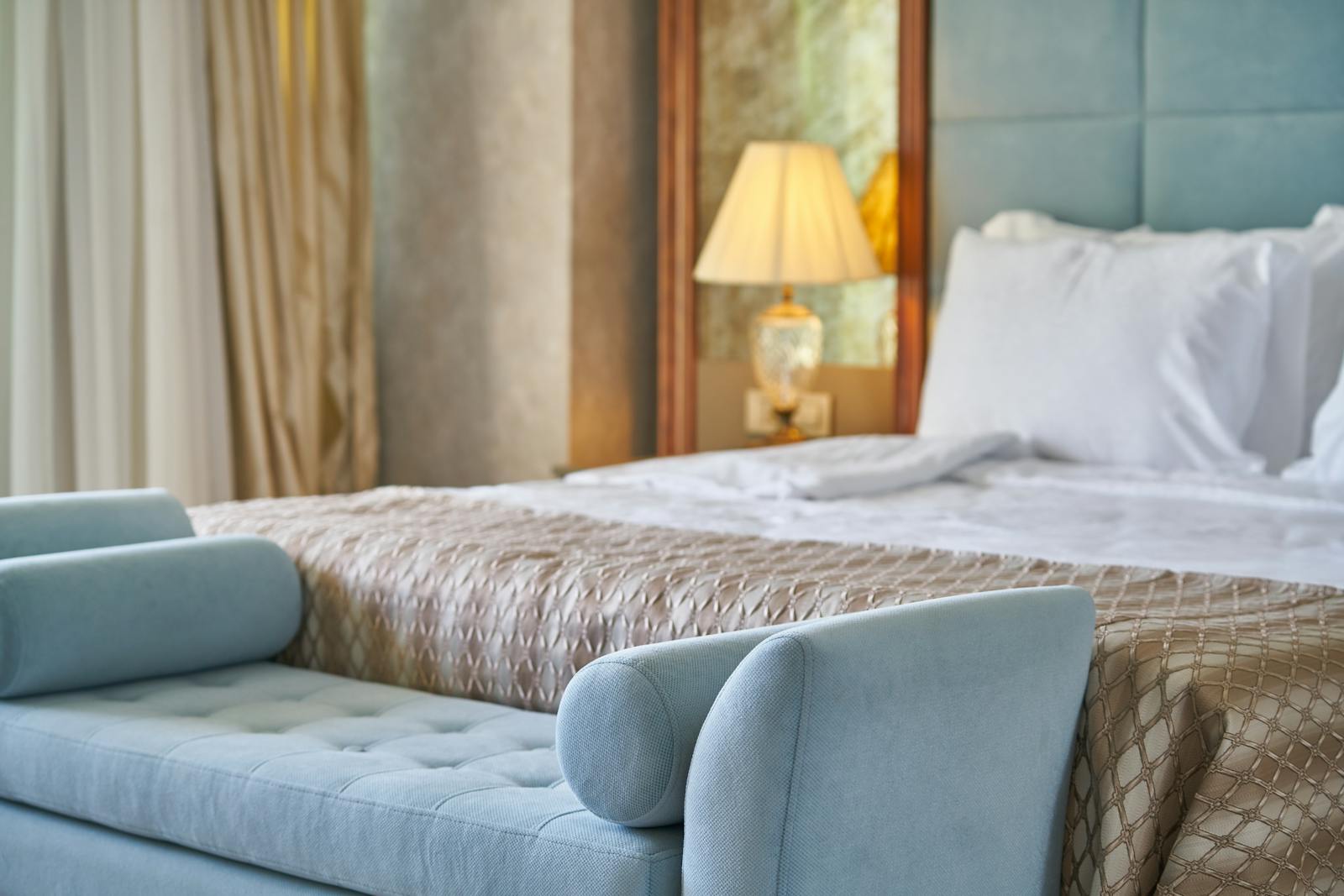 An elegant luxury hotel bedroom with a plush bed and warm, cosy lighting