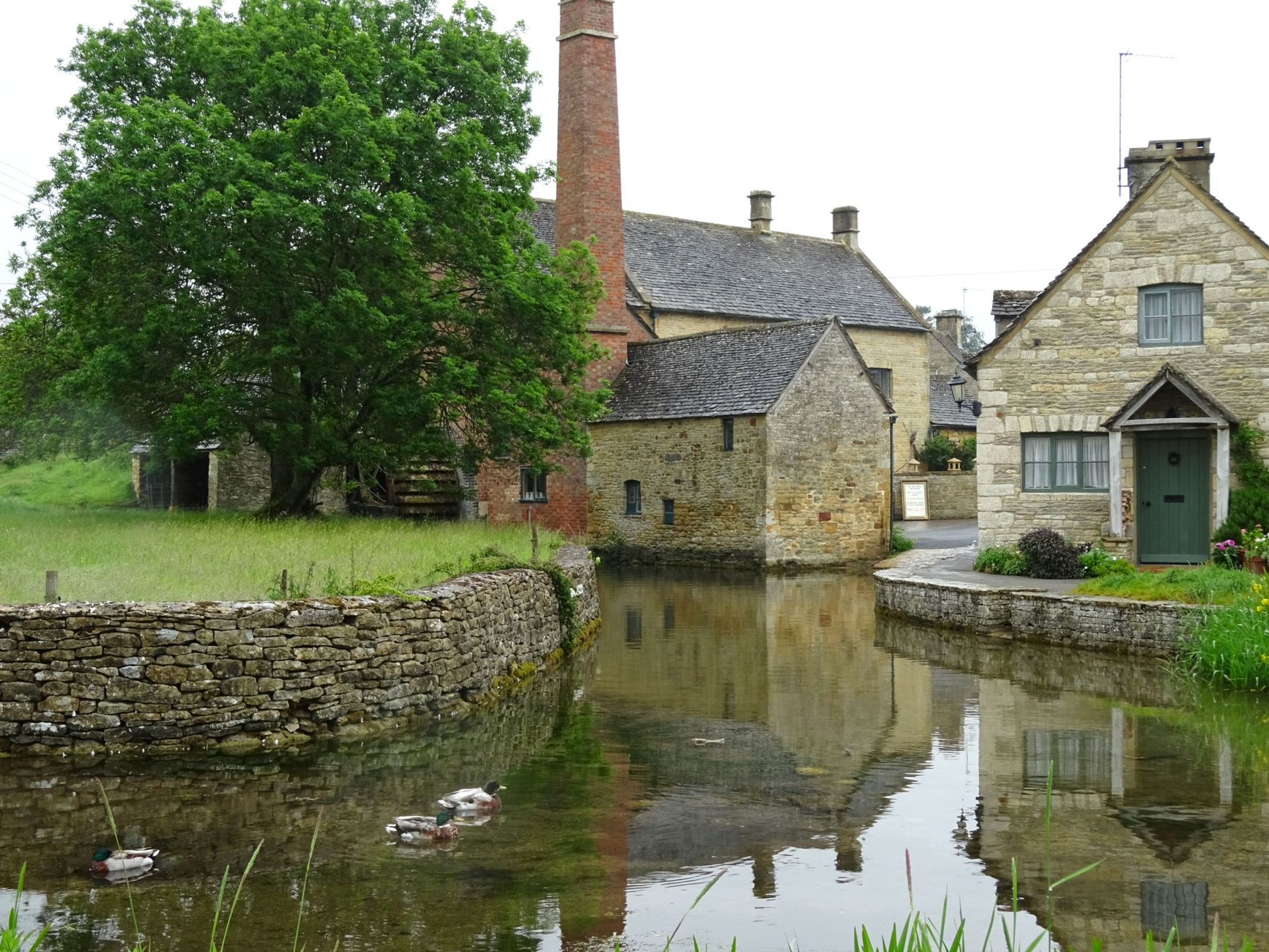 Old stone mill and millpond in a Cotswolds village near Bourton