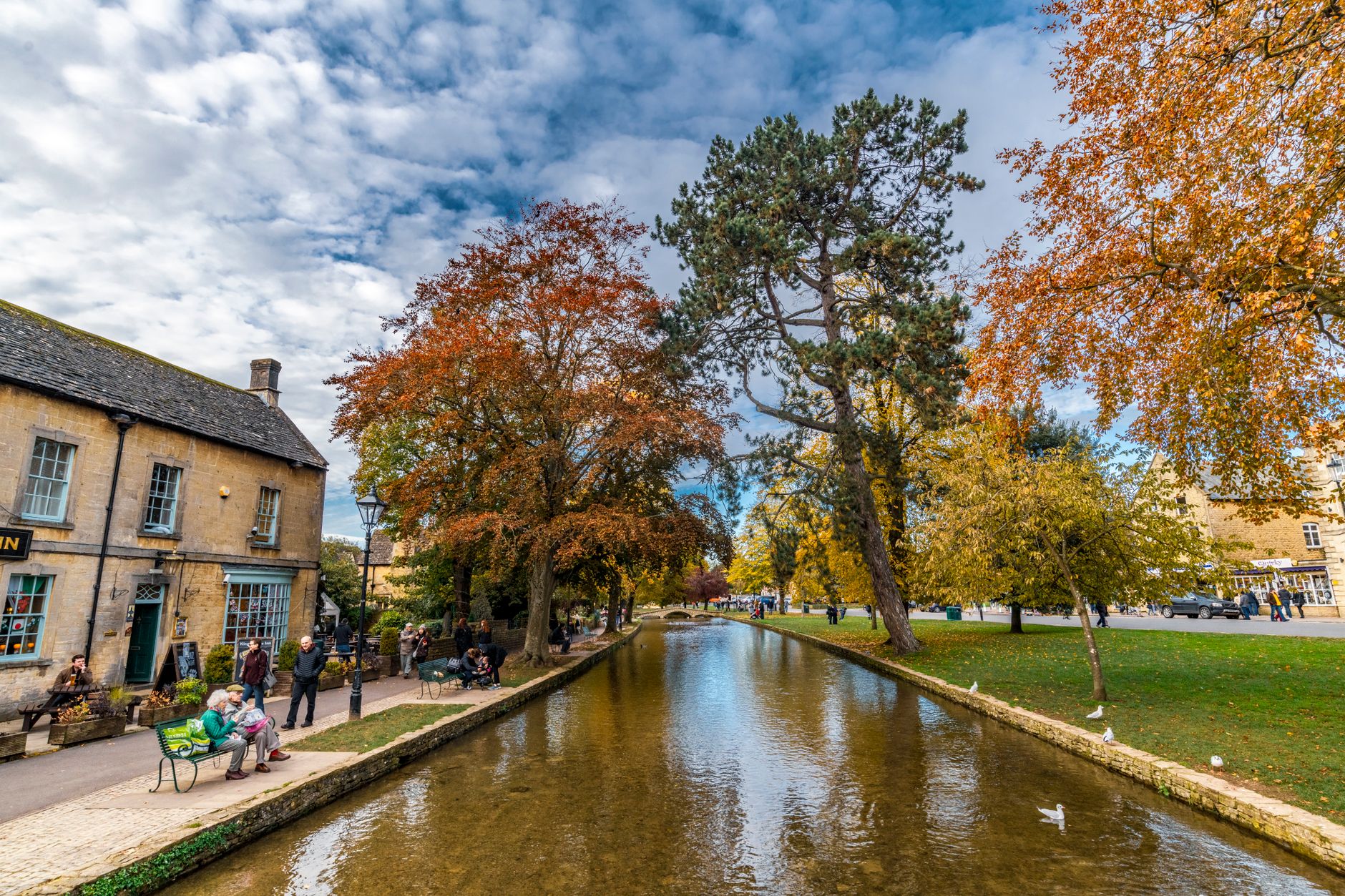 Stone footbridge over the shallow River Windrush in Bourton-on-the-Water in autumn