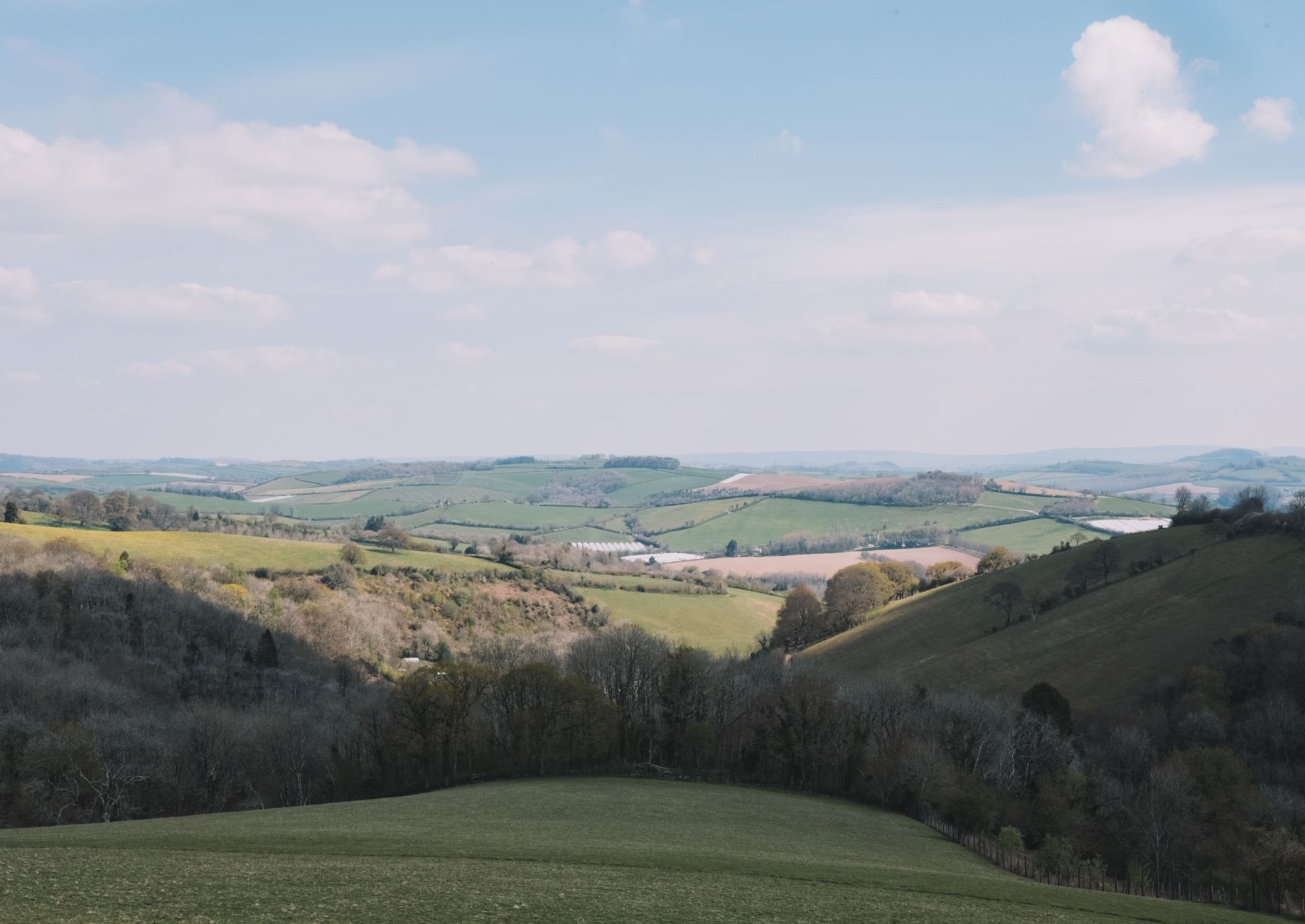 Panoramic view across rolling green Cotswold hills from the escarpment