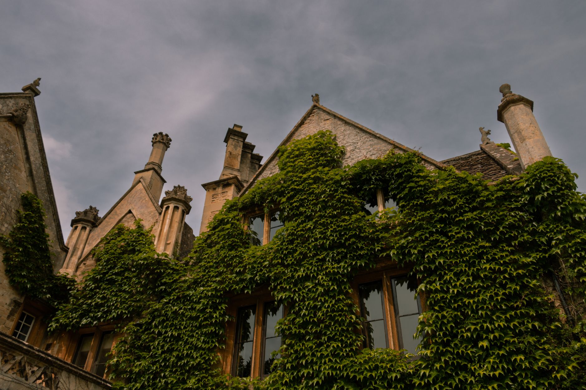 Ivy-covered Cotswold stone house with stone-tiled roof in Castle Combe