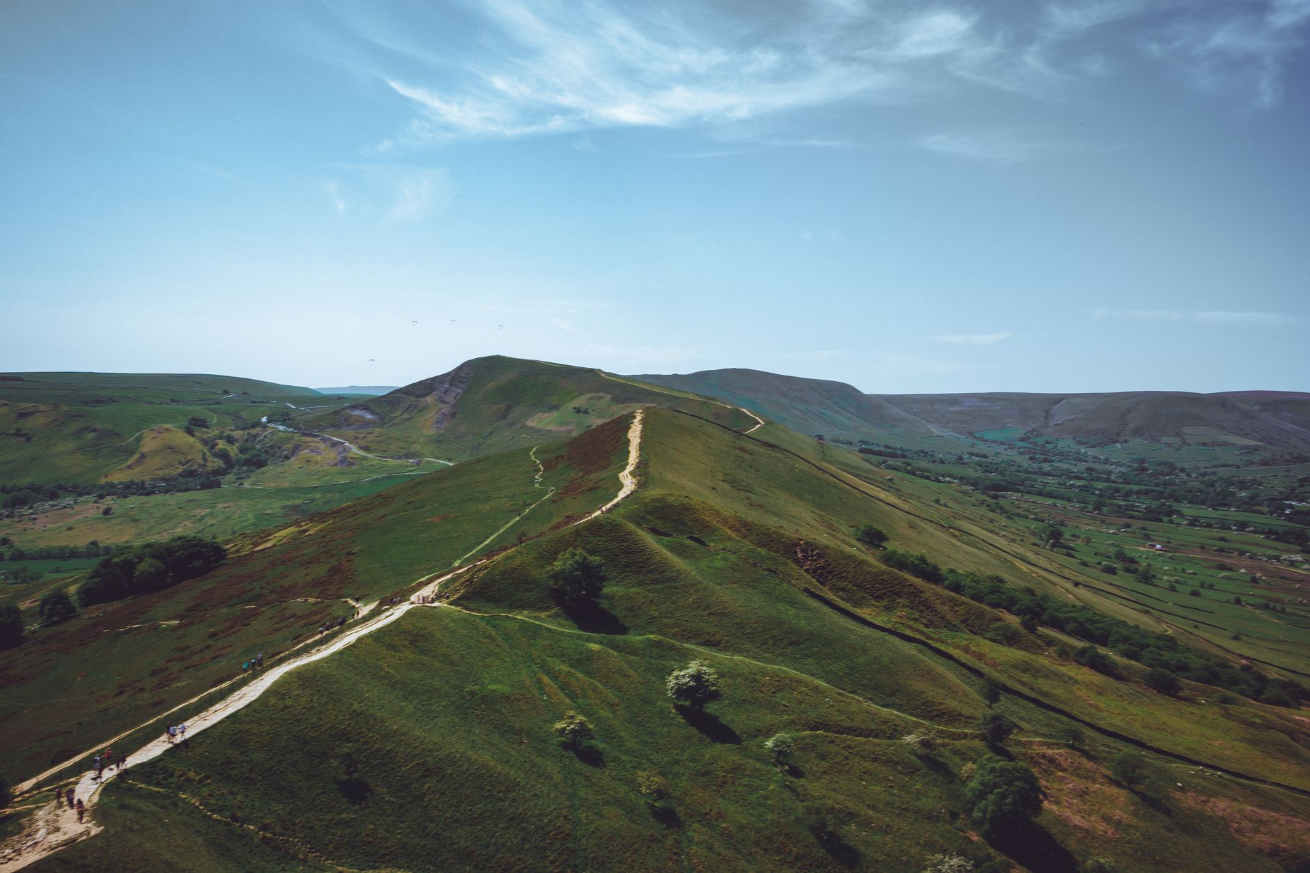 Footpath running along a grassy Cotswold escarpment with long views over the vale