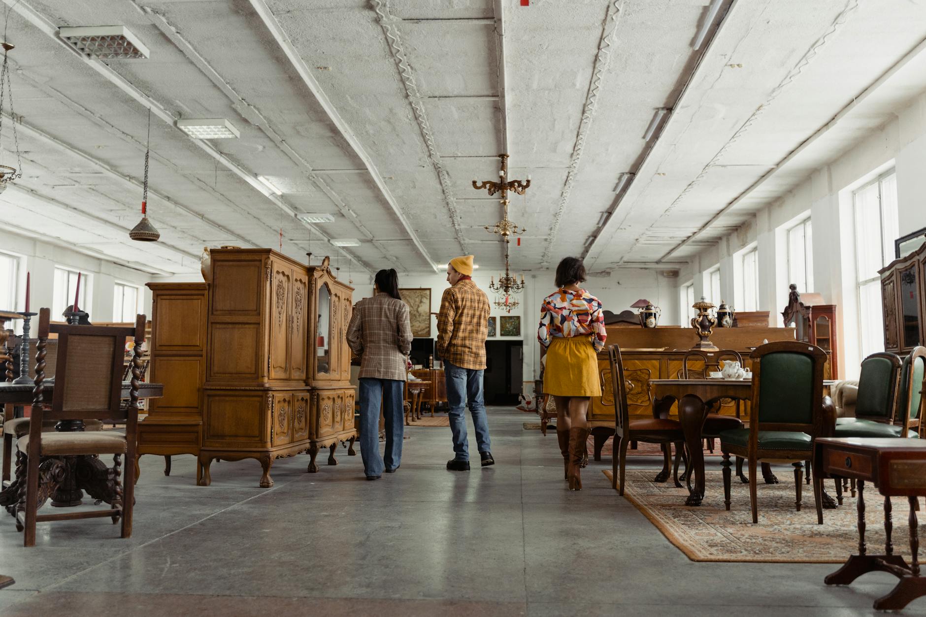 Shoppers browsing antique furniture in a Cotswolds dealer's showroom