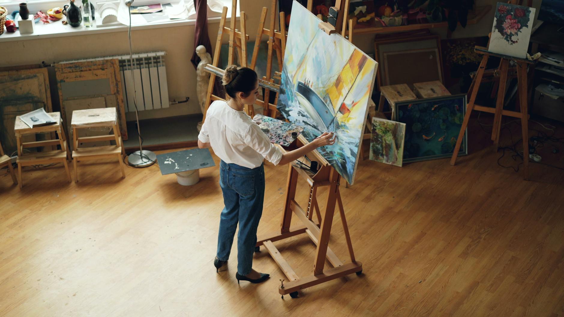 An artist at work on a painting in their Cotswolds studio
