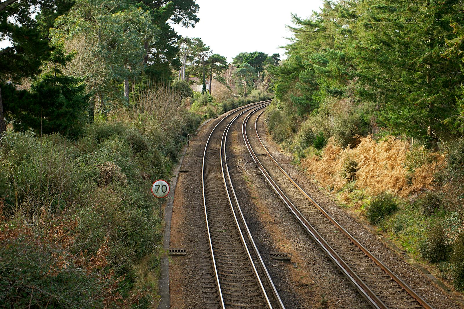 Railway tracks curving through lush green rural countryside