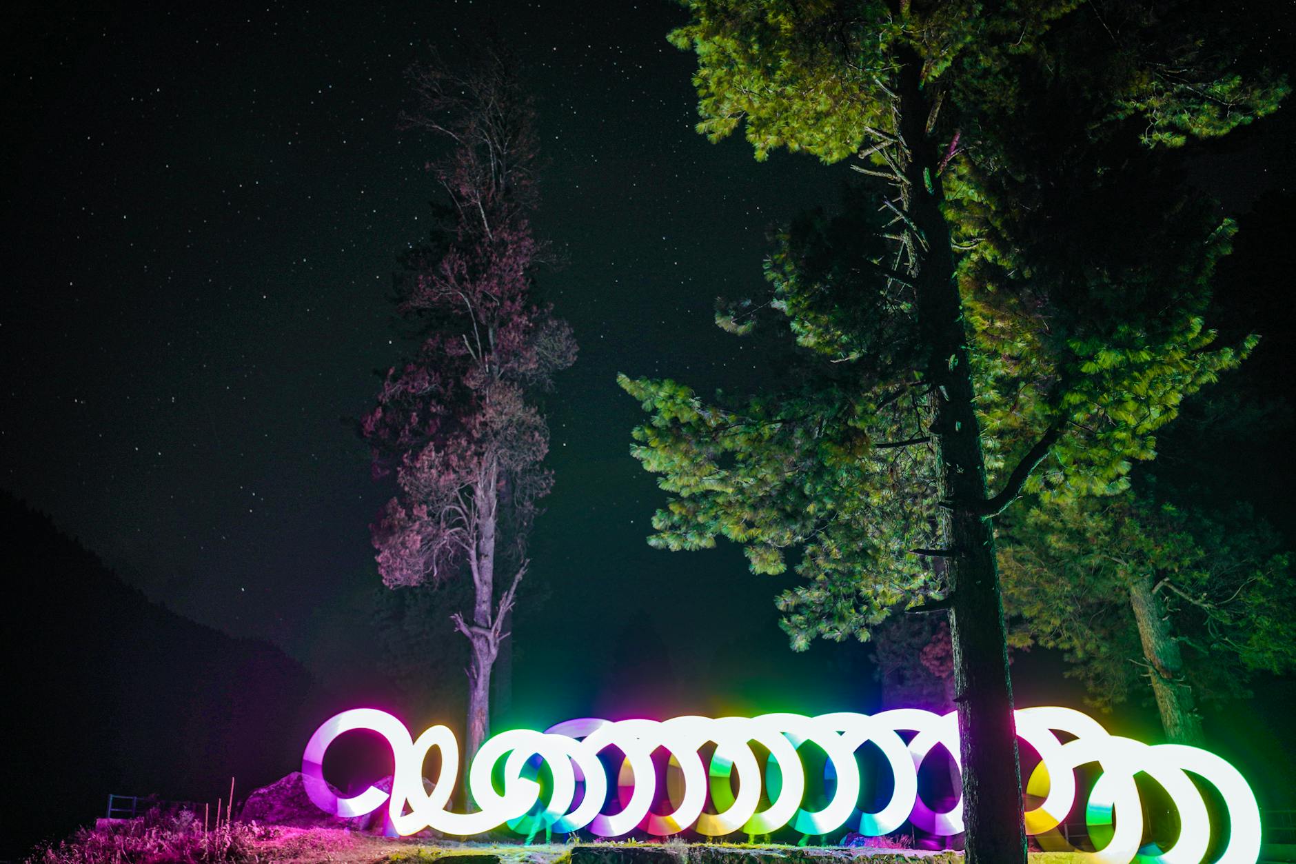 A glowing illuminated light installation on a Christmas light trail at night