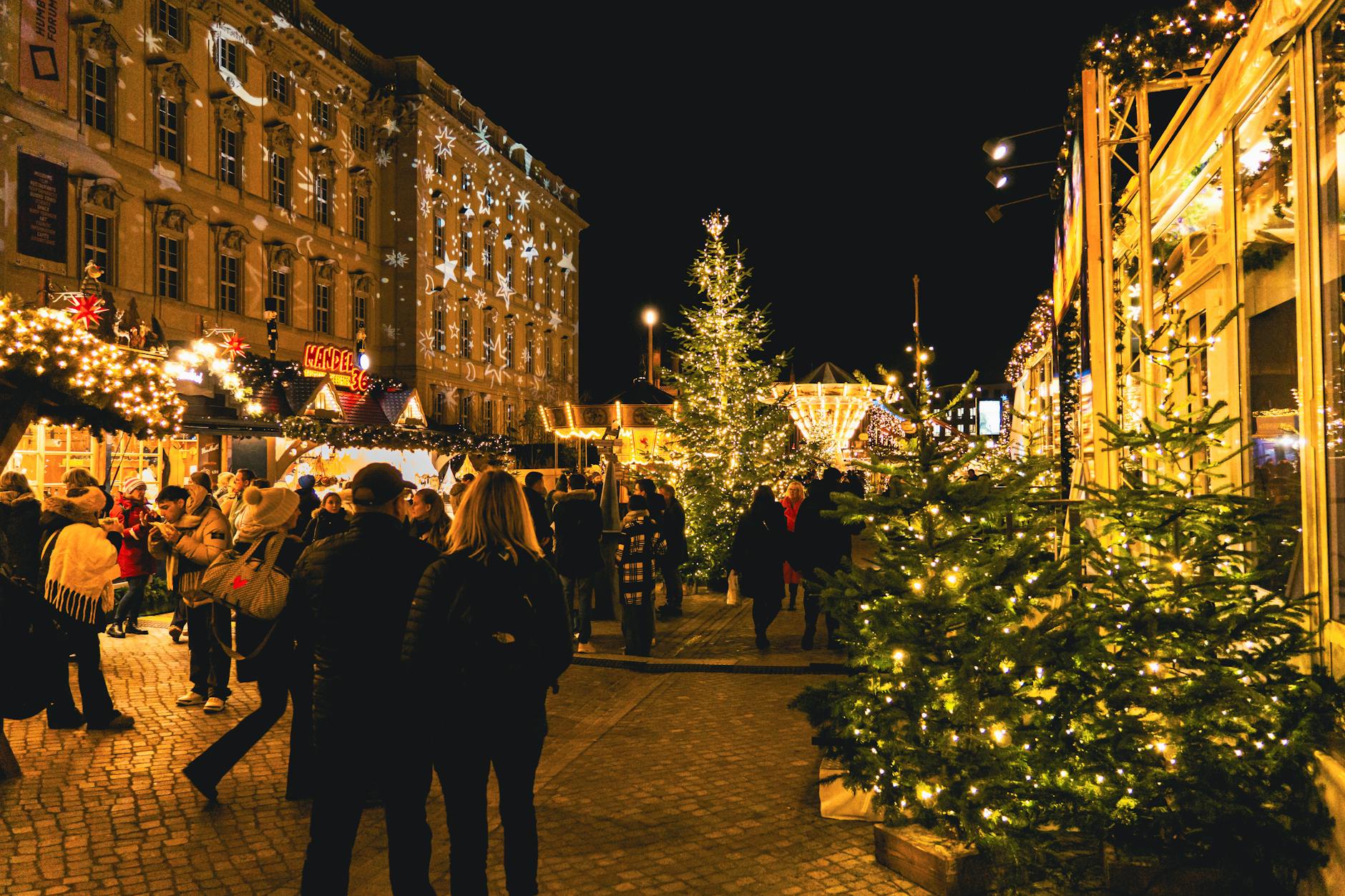 Illuminated wooden chalets and stalls at a festive Christmas market at night