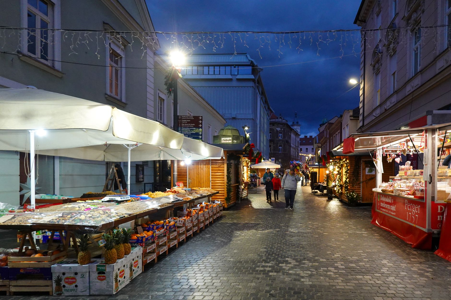 Festive Christmas market stalls lit up on a cobbled Cotswolds street