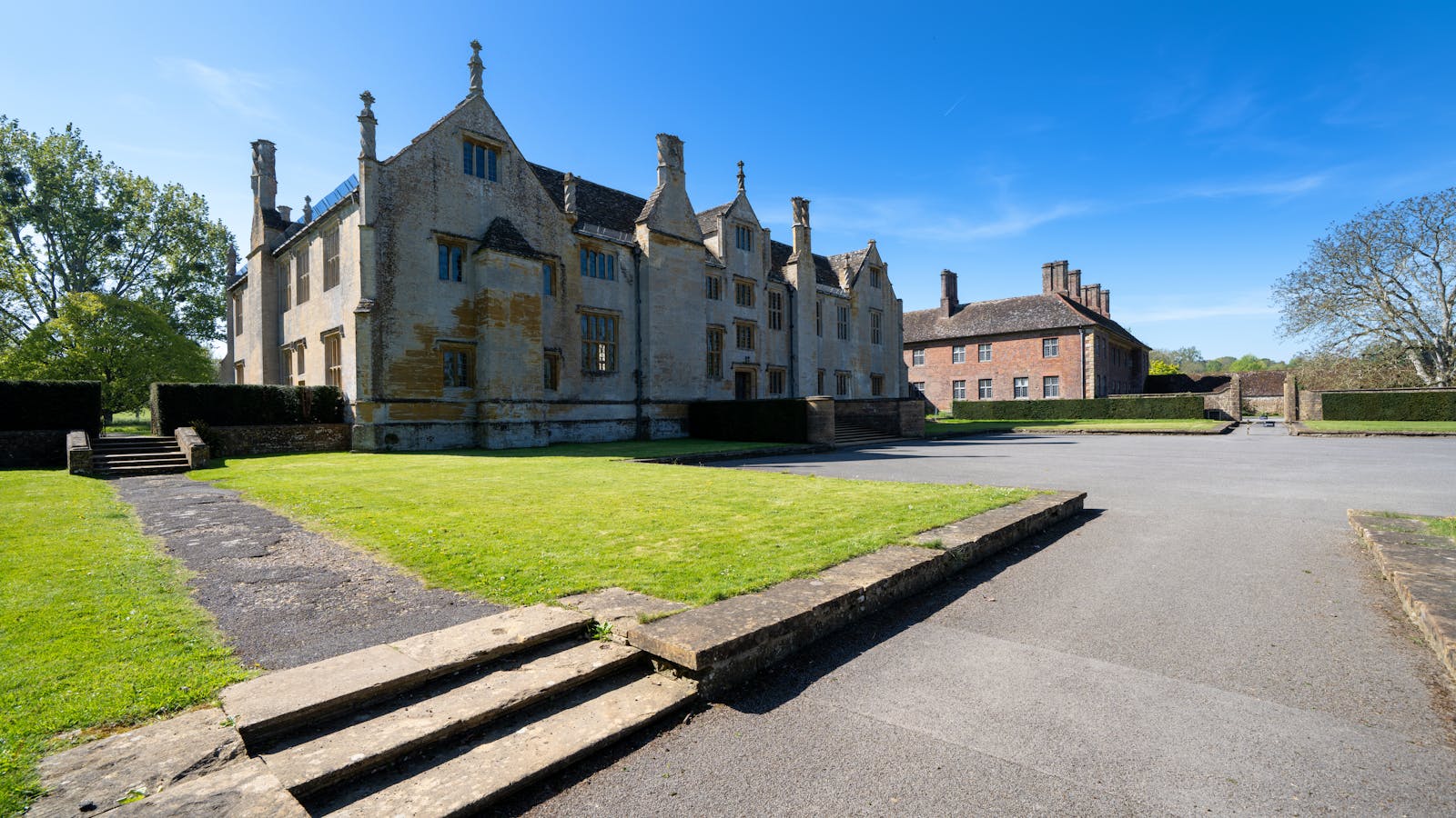 A historic Elizabethan-style English manor house of mellow stone in the Cotswolds