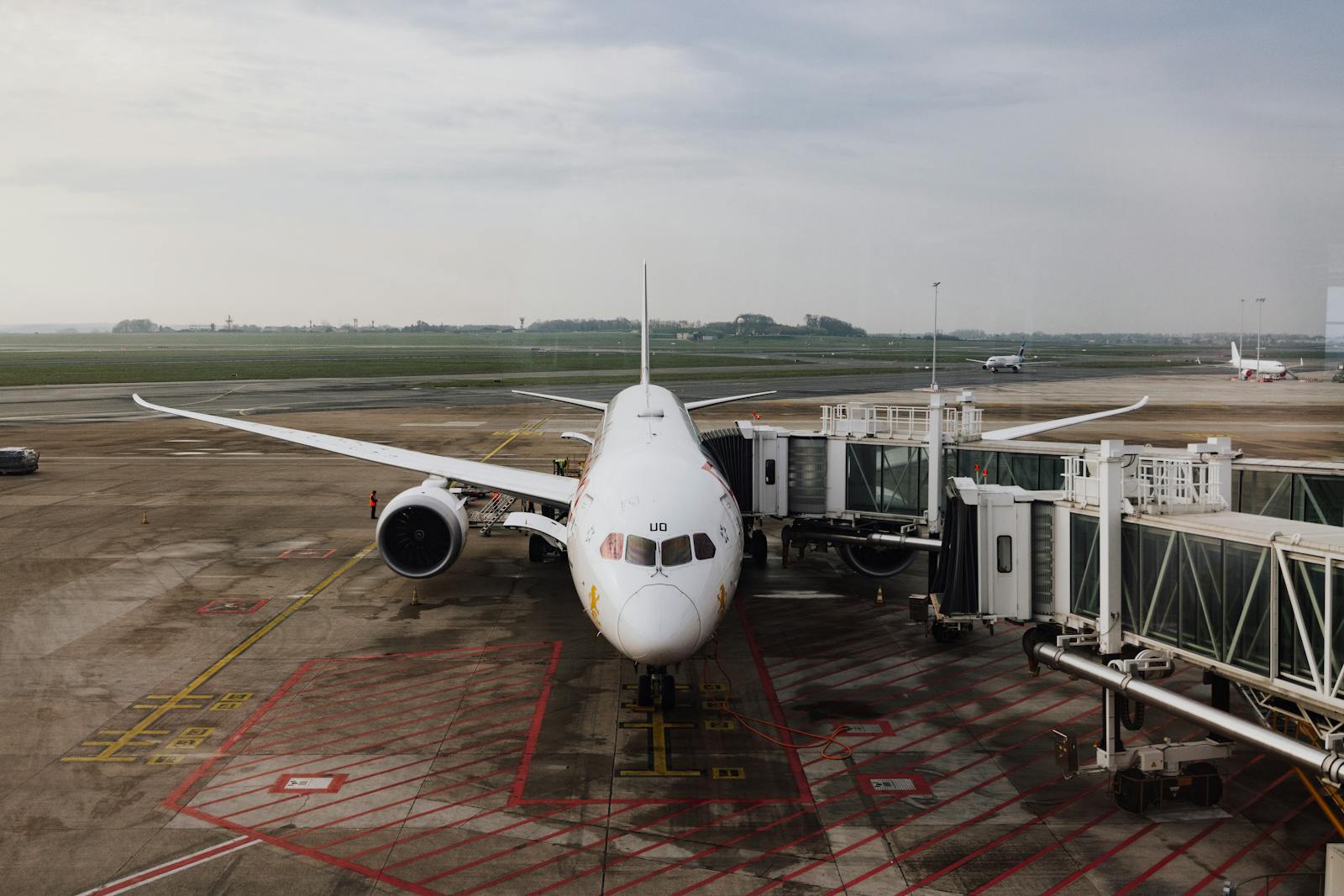 A modern jet airplane docked at an airport terminal gate