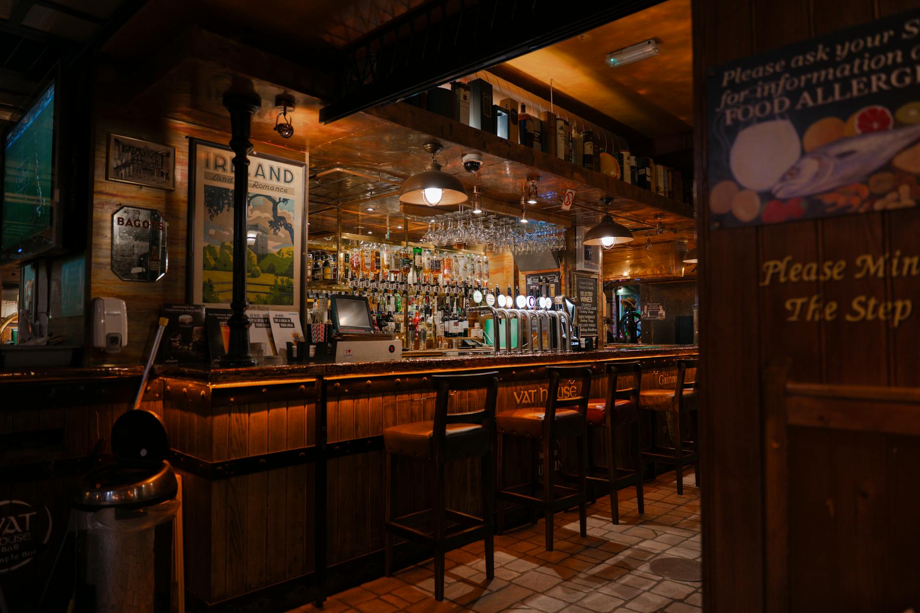 Cosy interior of a traditional Cotswolds pub with a warm wooden bar