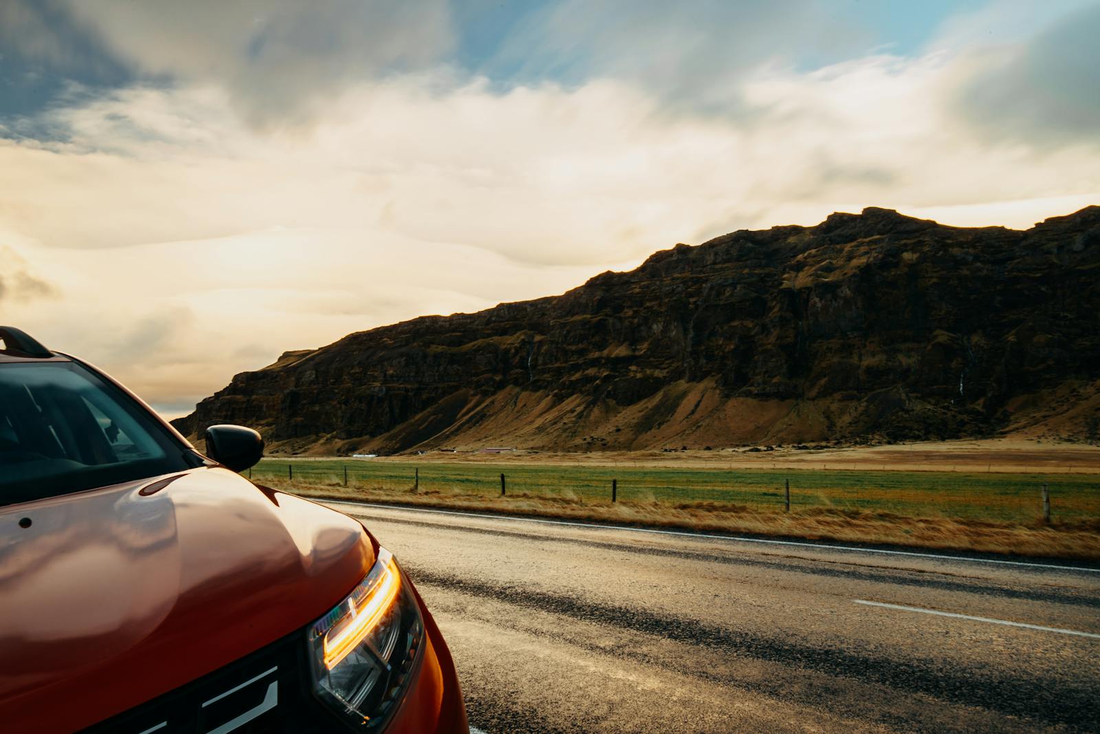 A car travelling along a rural road with rolling countryside views