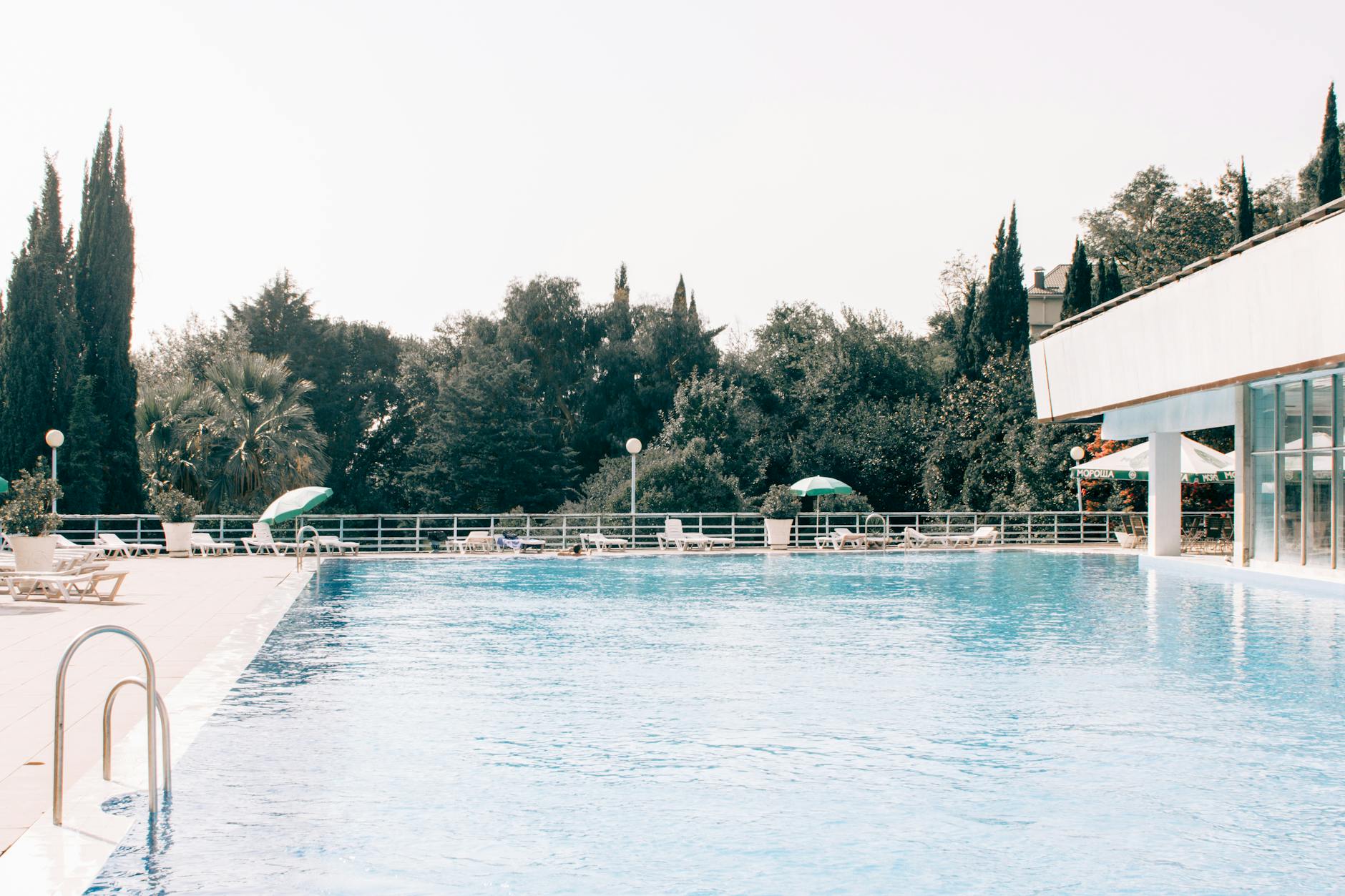 A clear-water outdoor swimming pool on a sunny day, like a Cotswold lido