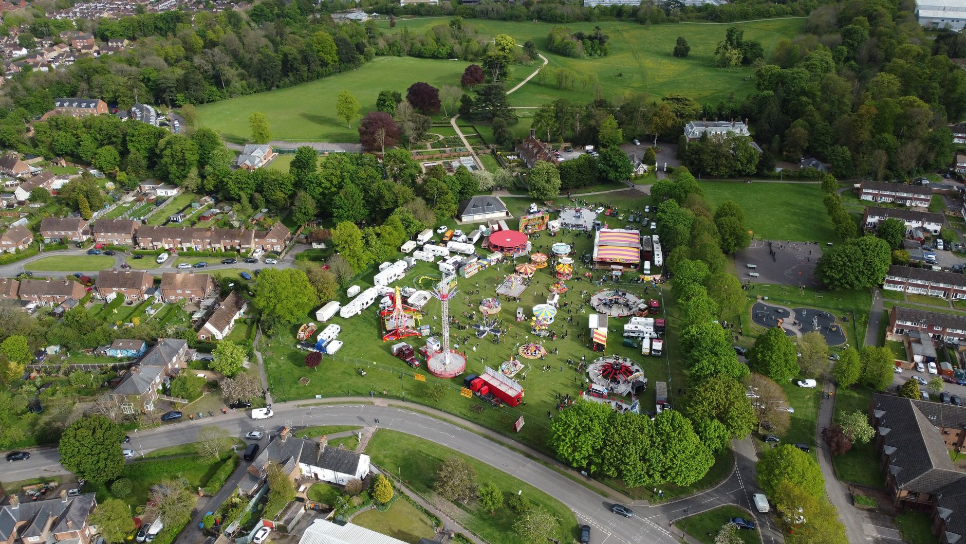 A colourful village funfair surrounded by greenery in England