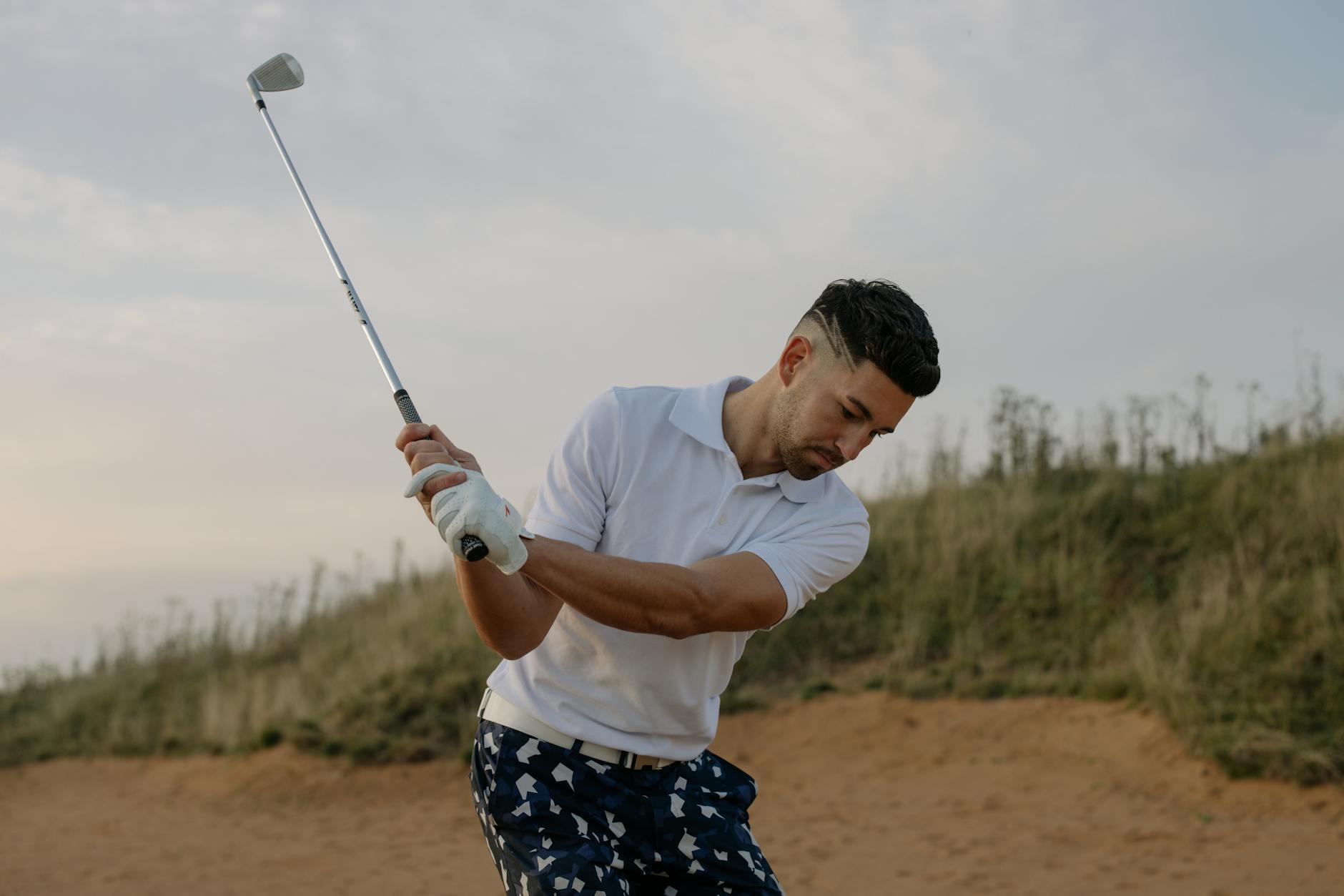 A golfer taking a swing on a picturesque golf course on a sunny day