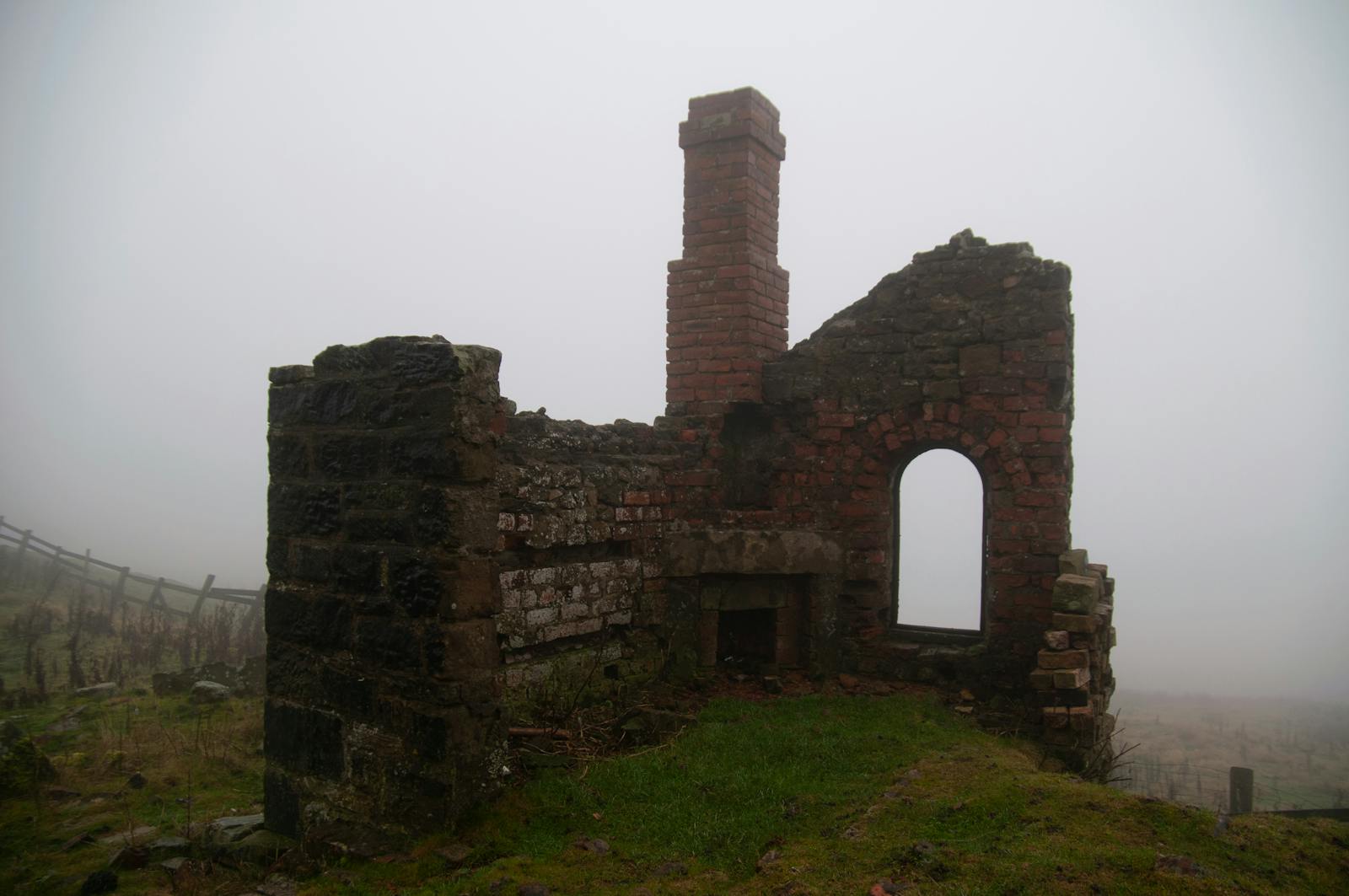 Eerie mist surrounding the ruins of an old stone building in the English countryside