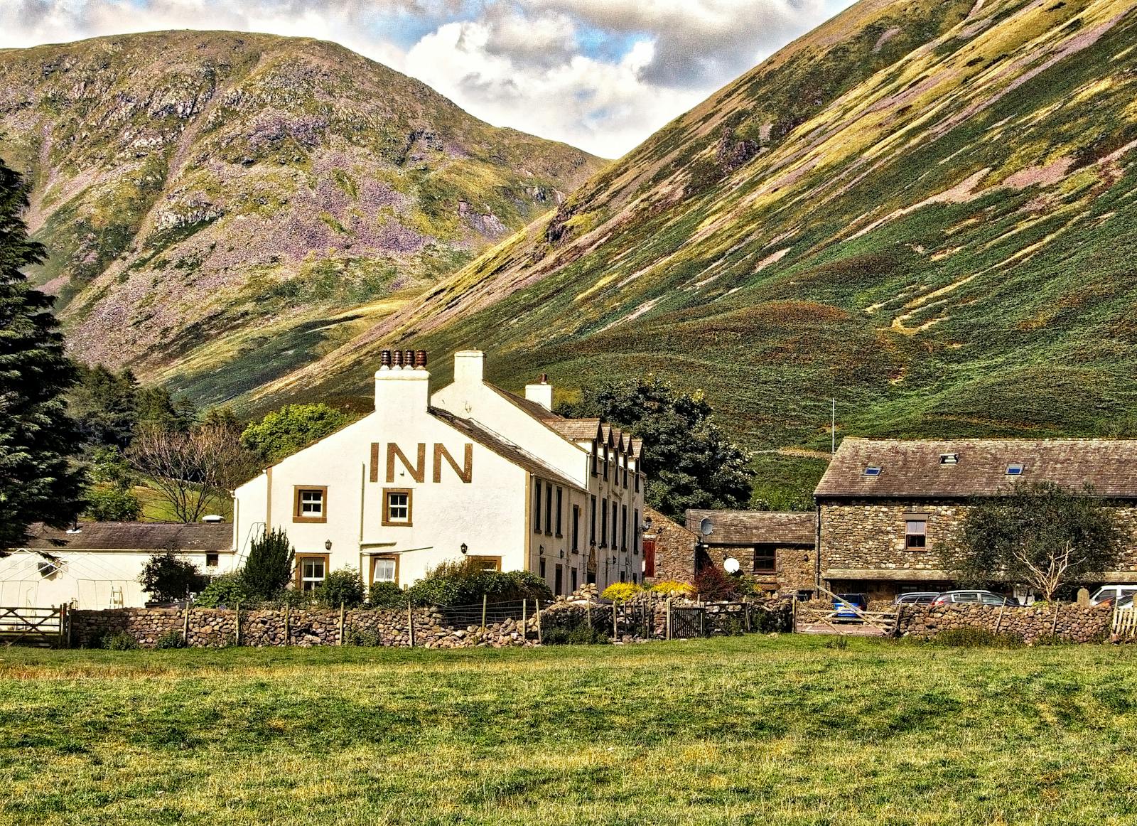 A historic stone country inn nestled against hills, like the old coaching inns of the Cotswolds