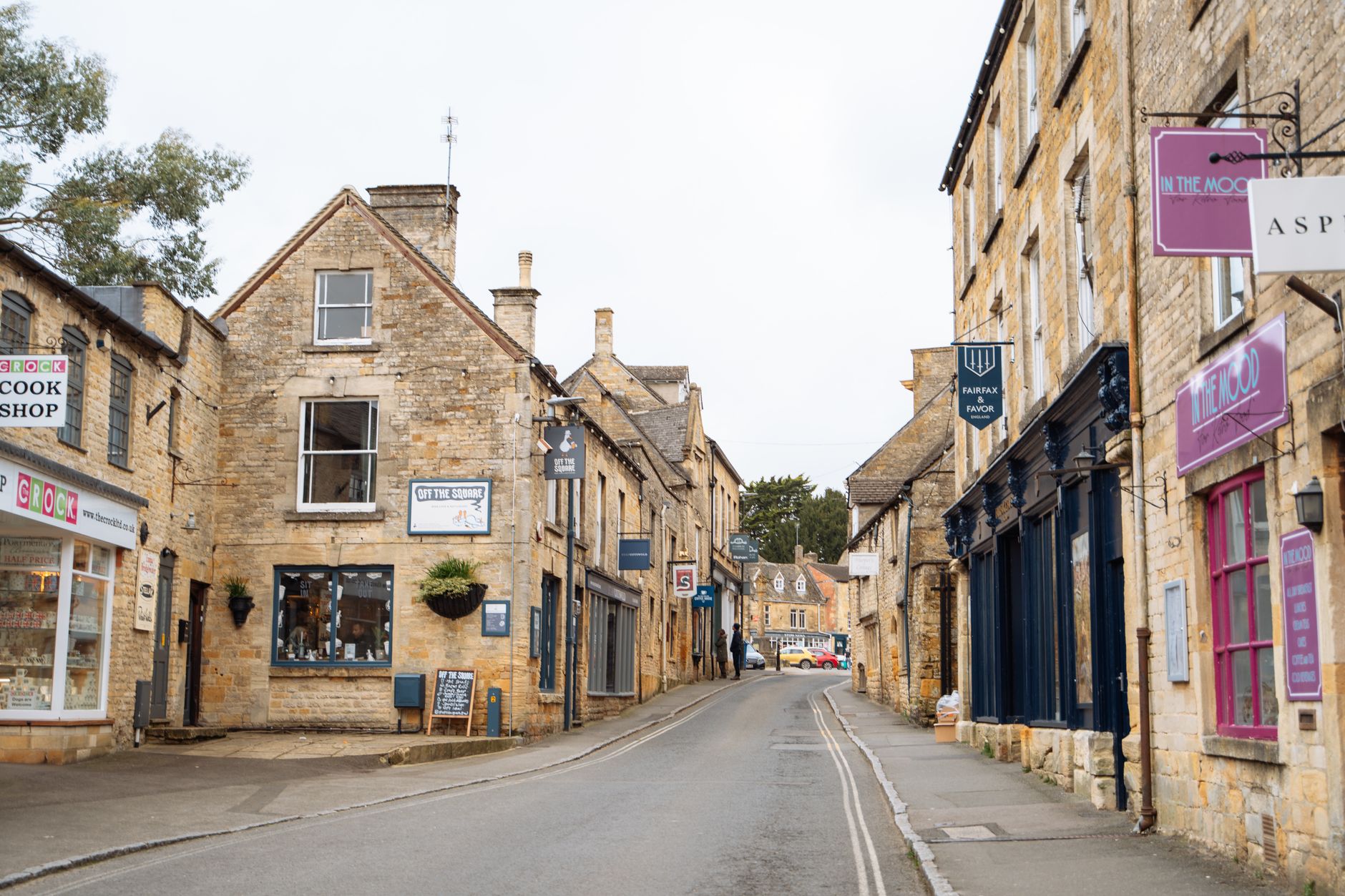 Street of pale honey-coloured Cotswold stone houses in Painswick