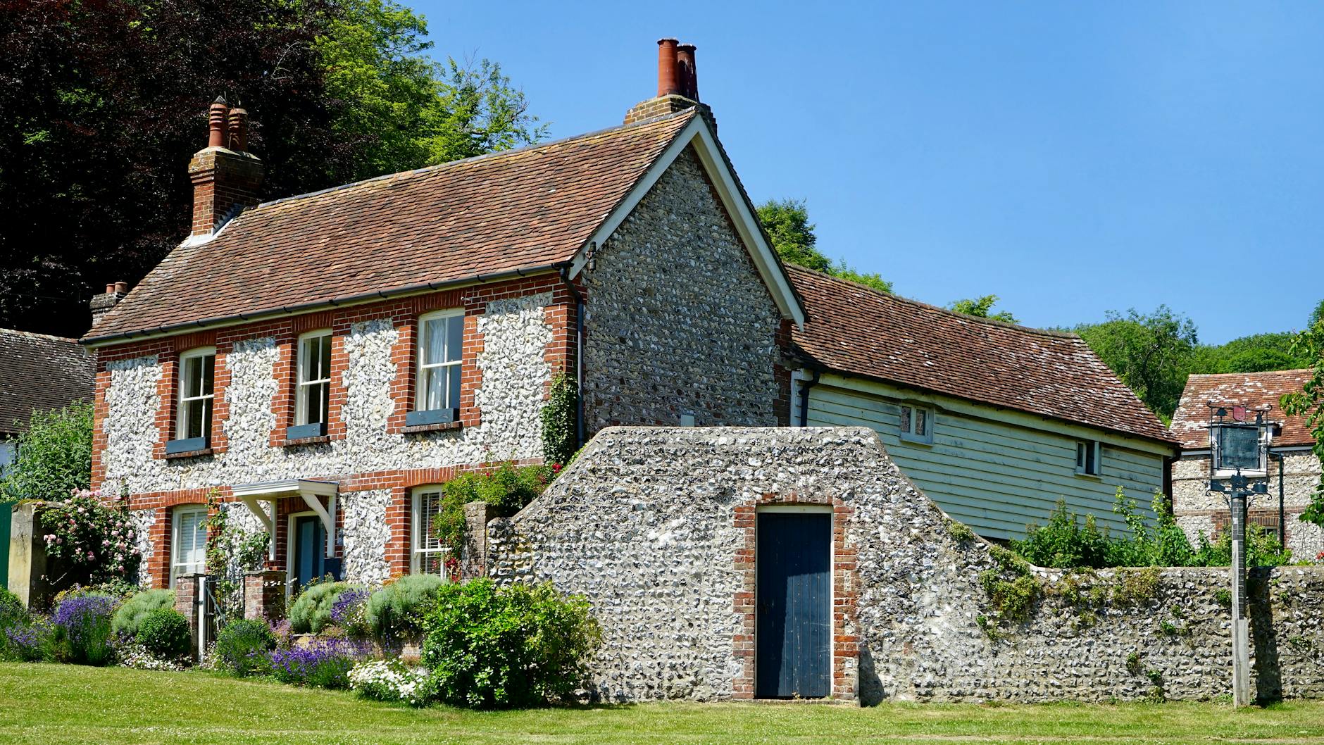 Honey-stone Cotswolds holiday cottage exterior with garden
