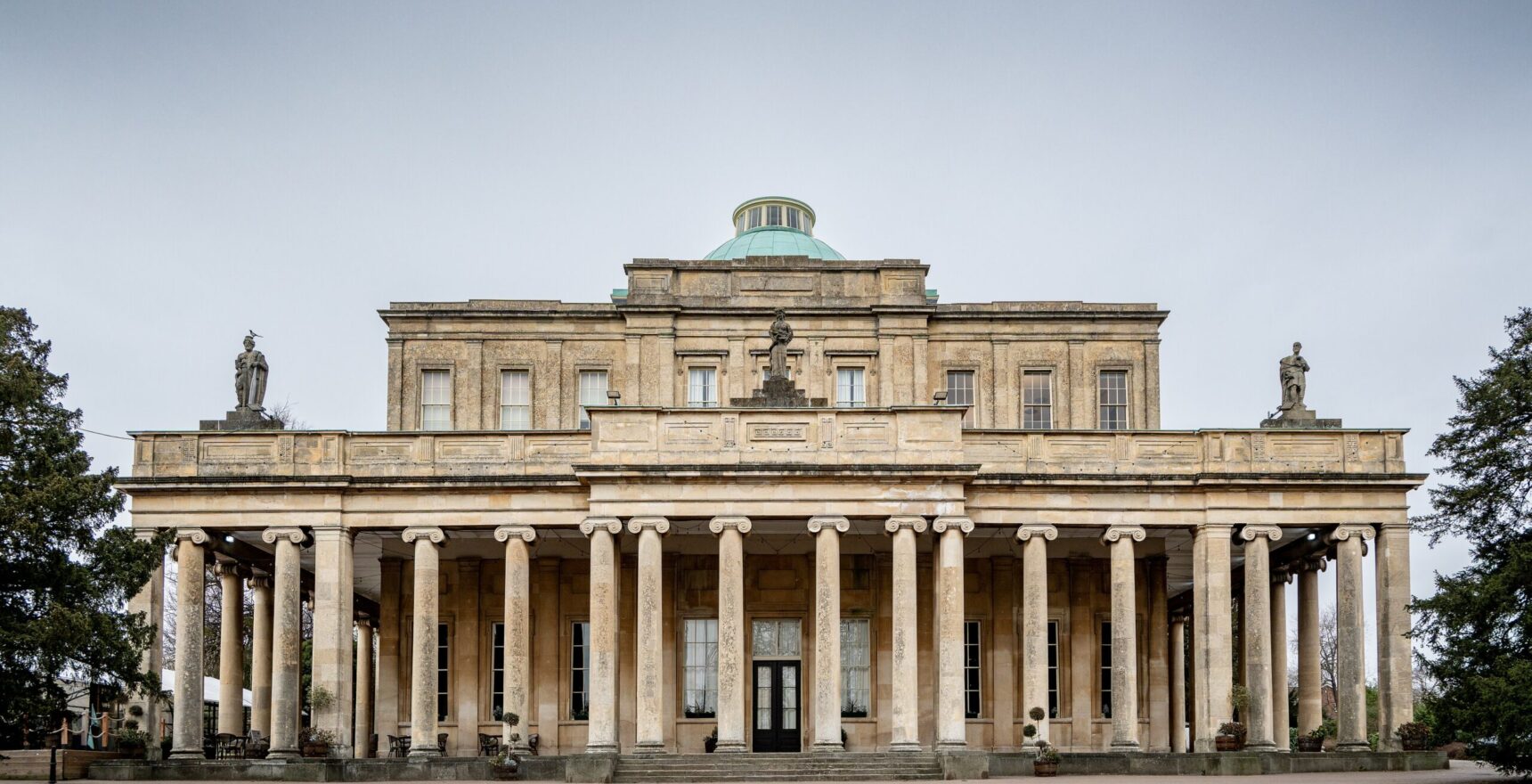 The Ionic colonnade and green dome of the Pittville Pump Room in Cheltenham