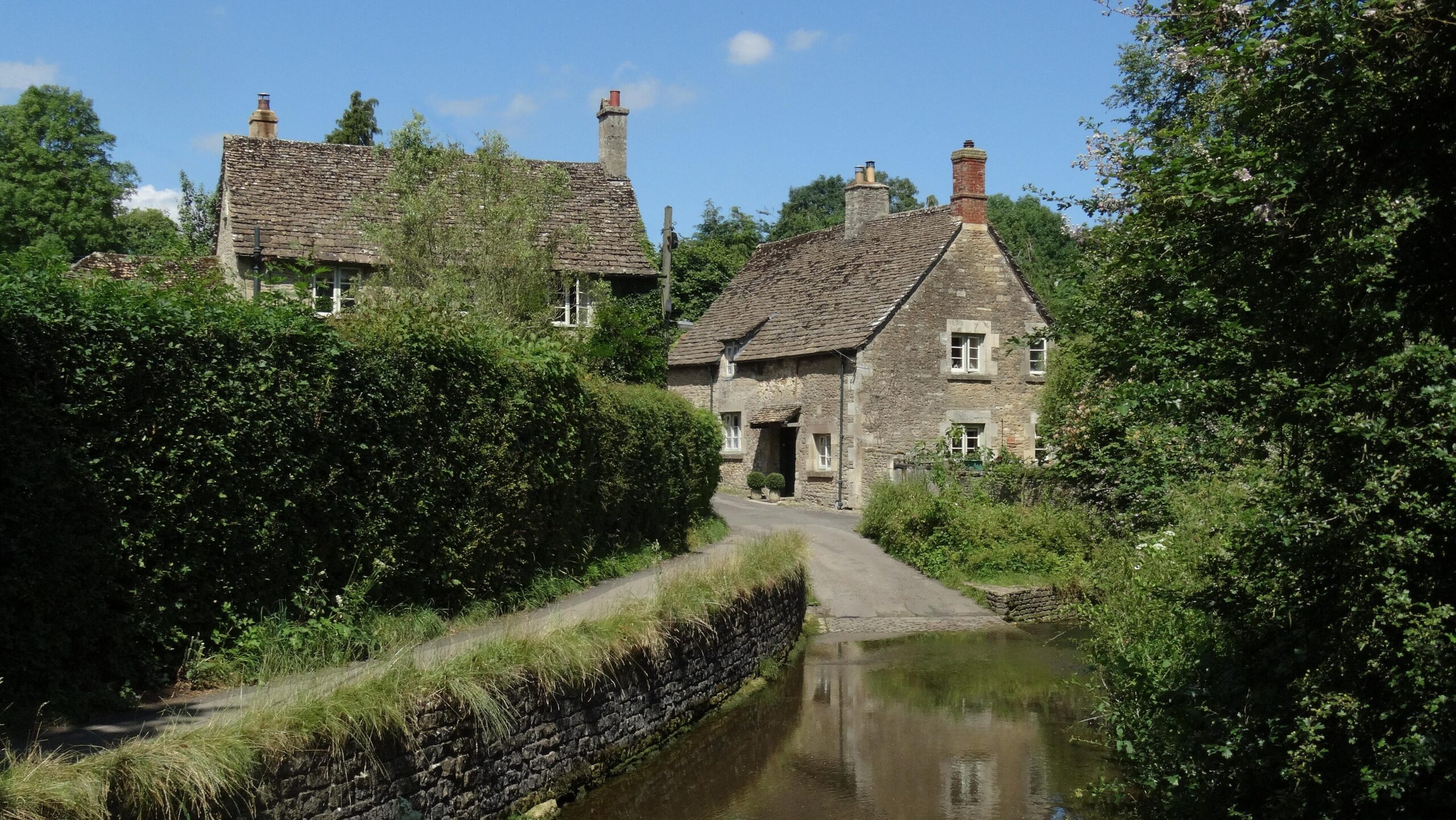 Cottages on Nethercote Hill in Lacock beside the ford across the Bide Brook, with the lane running down into shallow water