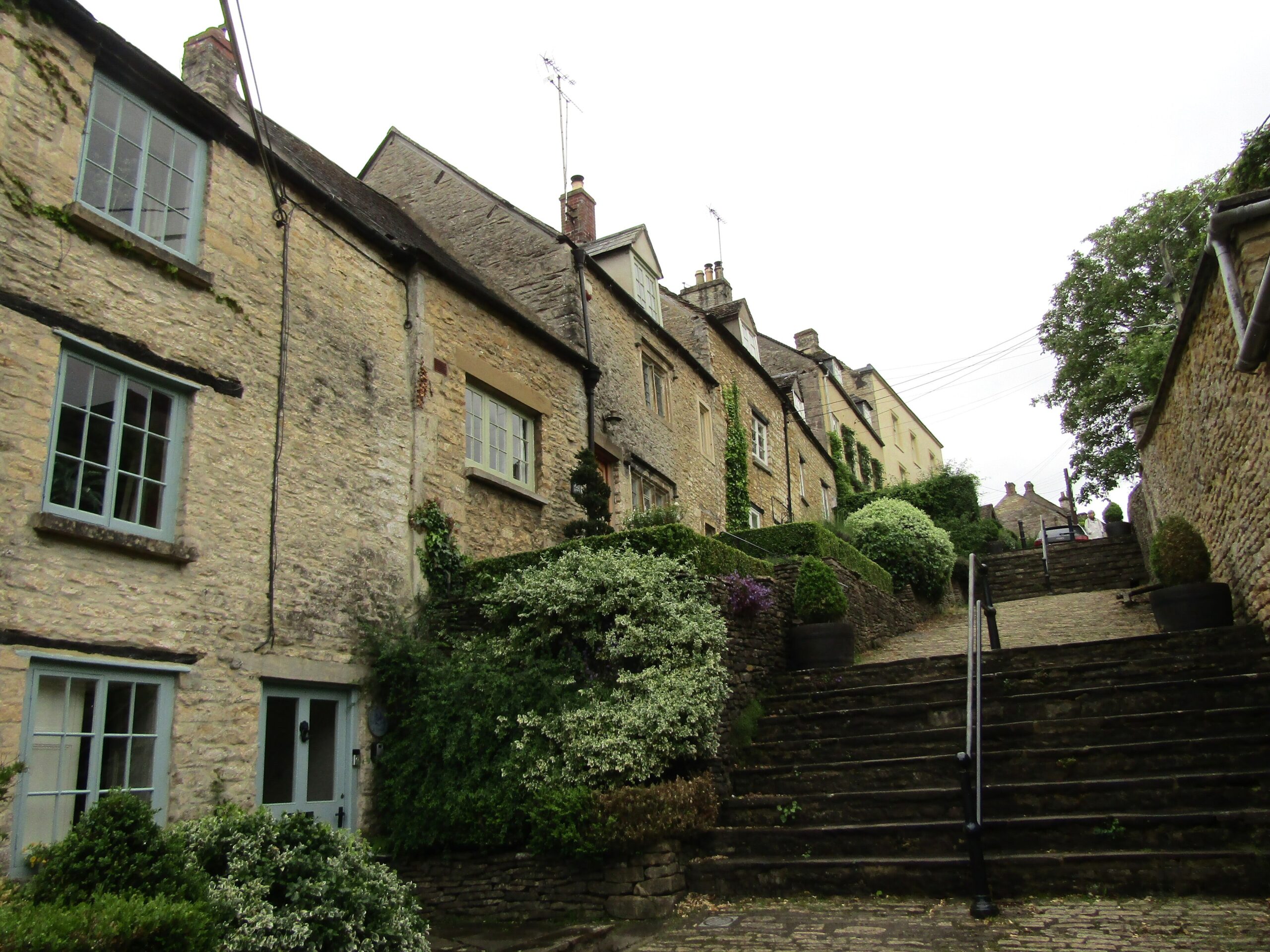 The Chipping Steps in Tetbury running steeply up between a stepped terrace of honey-stone weavers' cottages