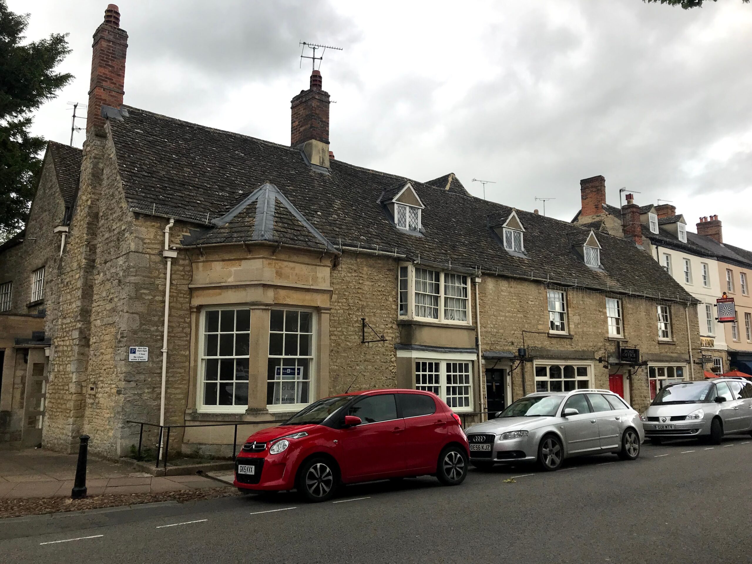 Stone cottages with dormer windows and a village post office along Park Street in Woodstock, Oxfordshire